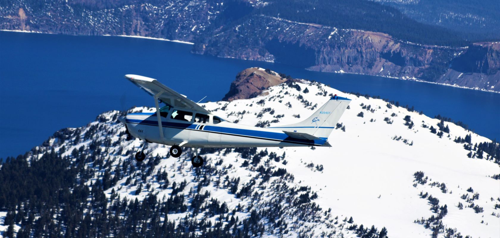 A Plane Flying Over A Snow Covered Mountain